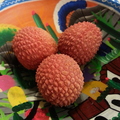 Three lychee berries in a bowl