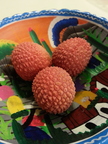 Three lychee berries in a bowl
